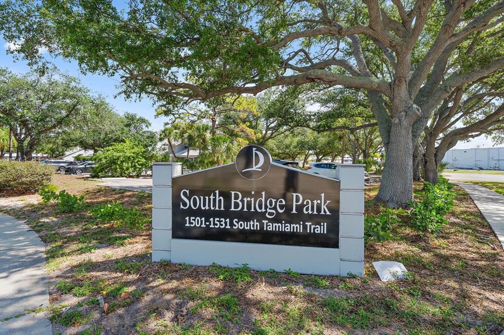 A sign for South Bridge Park stands outdoors beneath large oak trees — 1521 TAMIAMI TRAIL S UNIT 3A, VENICE, FL
