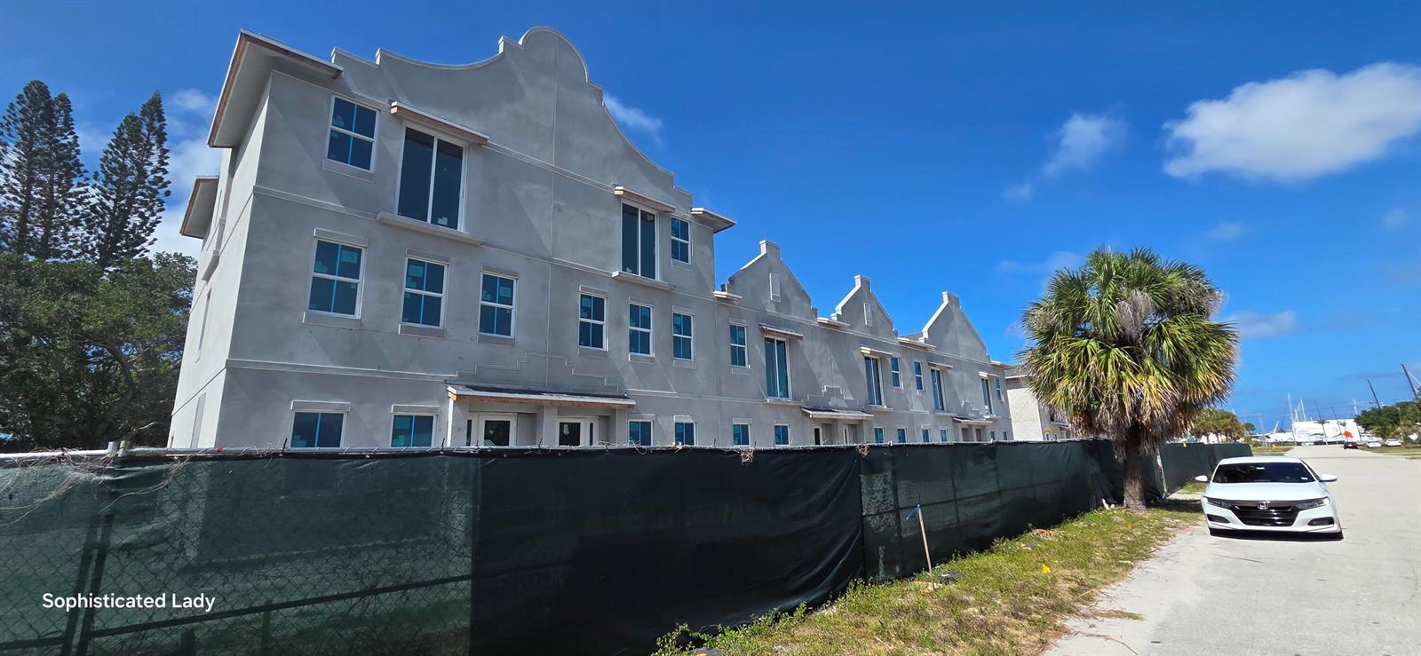 A multi-story residential building under construction features a gray stucco exterior and multiple windows — 132 W 11th Street, Riviera Beach FL 33404, RIVIERA BEACH, FL