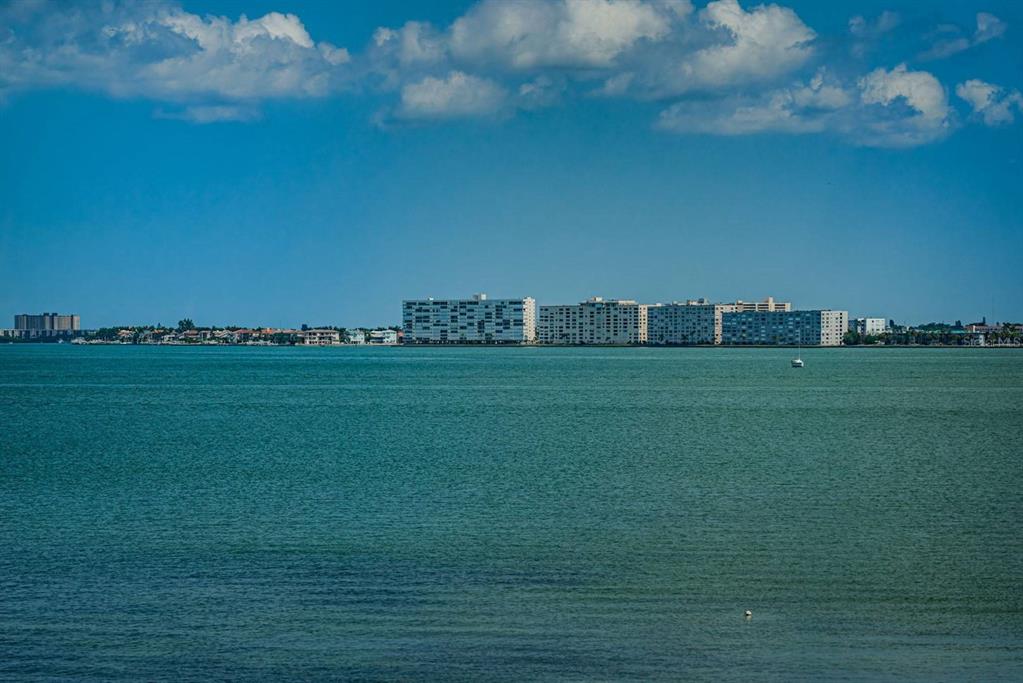 A wide view of a calm bay with a distant shoreline featuring several large apartment buildings — 5151 ISLA KEY BOULEVARD S UNIT 220, ST PETERSBURG, FL