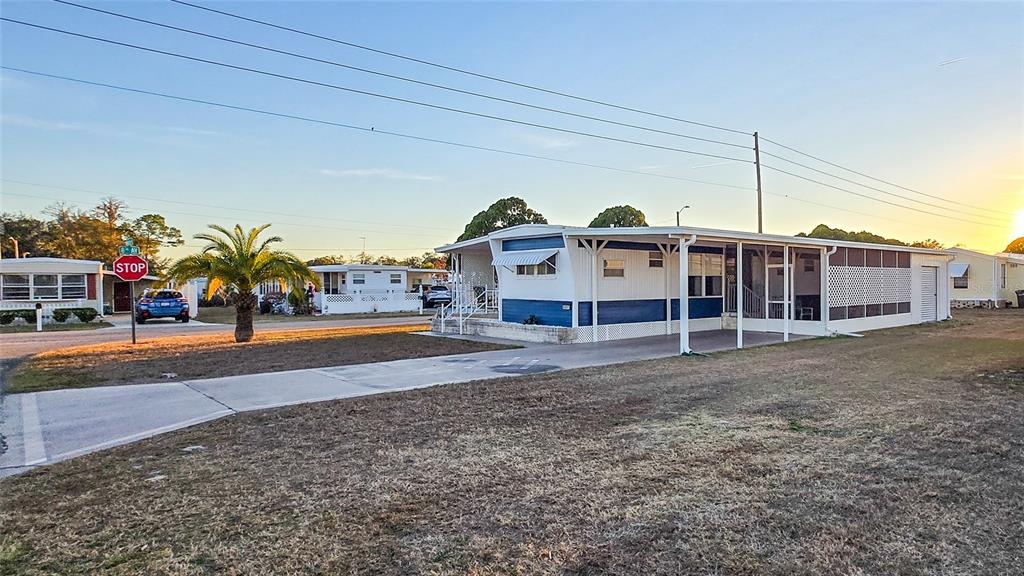 A single-story mobile home with a blue and white exterior sits on a paved lot — 5227 BETTY STREET, ZEPHYRHILLS, FL