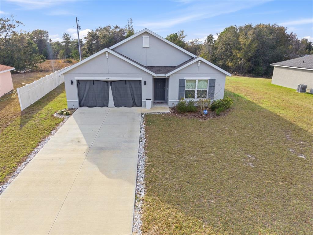 A single-story house with a gray exterior, a two-car garage, and a concrete driveway — 16402 SW 17TH TERRACE ROAD, OCALA, FL