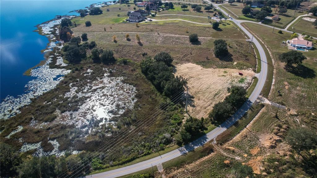 An aerial view shows a vacant, partially cleared lot situated between a road and a lake — 0 CHERRY LAKE ROAD, GROVELAND, FL