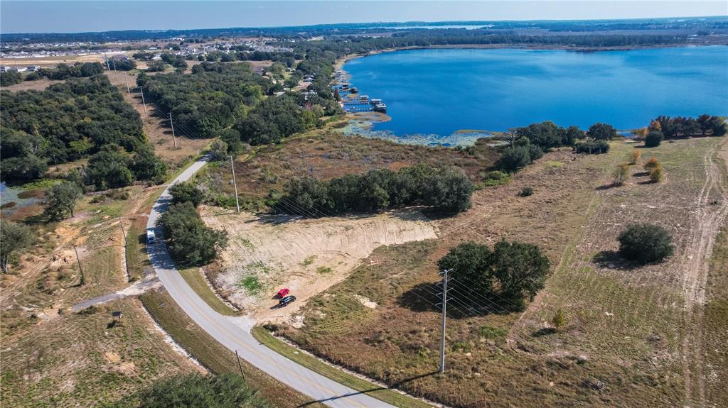 An aerial view shows a vacant, partially cleared lot next to a road and lake — 0 CHERRY LAKE ROAD, GROVELAND, FL