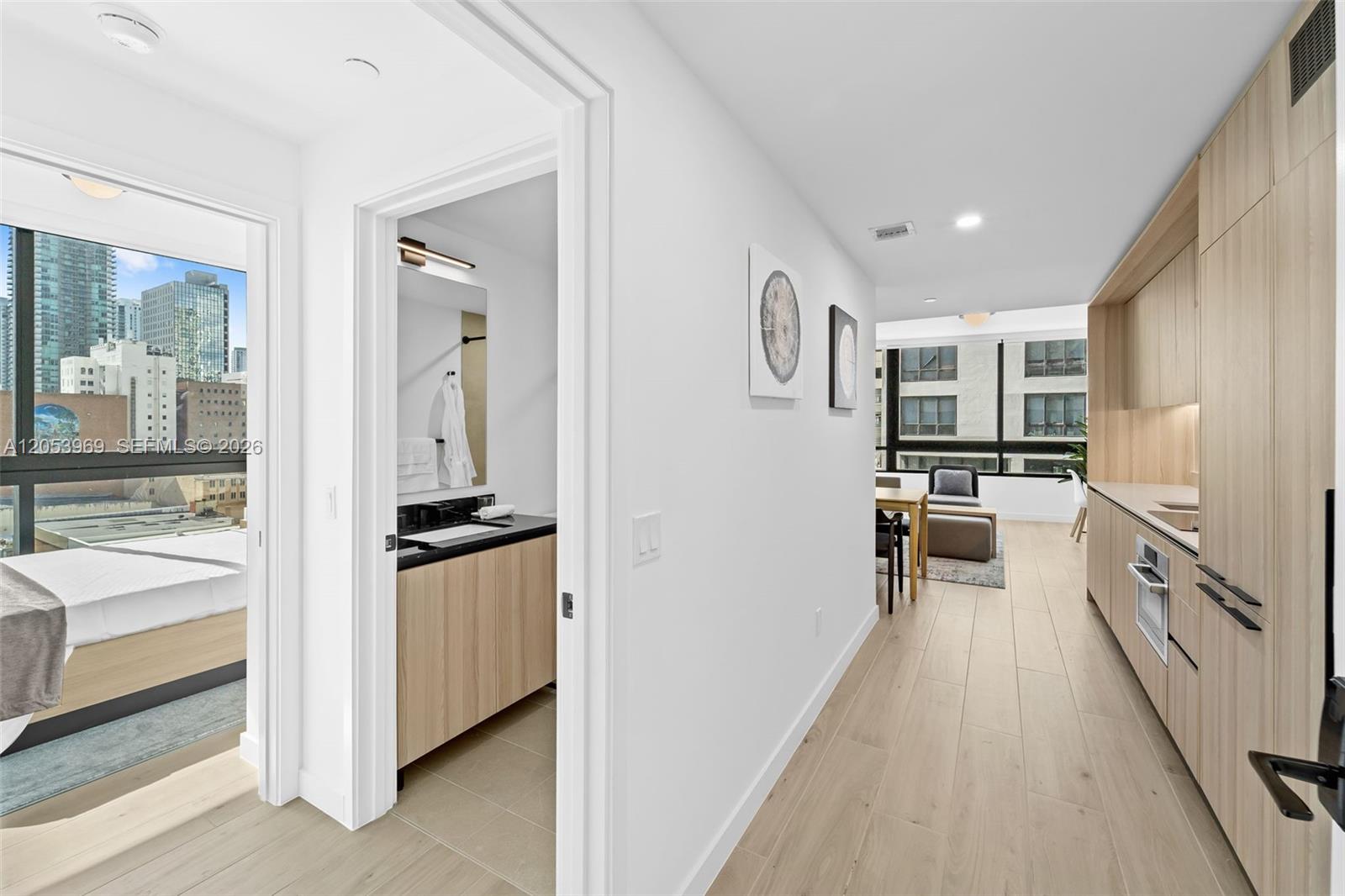 A modern apartment interior features a kitchen, a bathroom, and a bedroom with city views — 225 N Miami Ave # 912, Miami FL 33128, MIAMI, FL