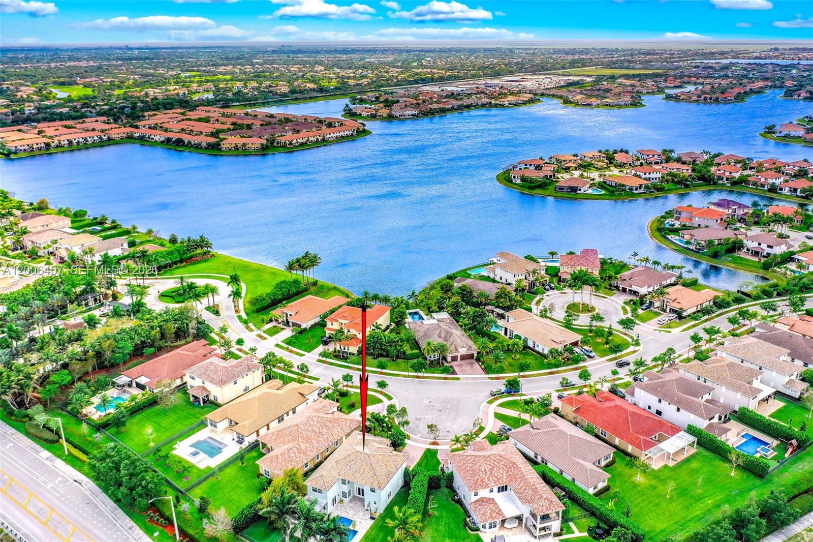 An aerial view of a residential neighborhood featuring houses with pools surrounding a large lake — 8766 Miralago Way, Parkland FL 33076, PARKLAND, FL