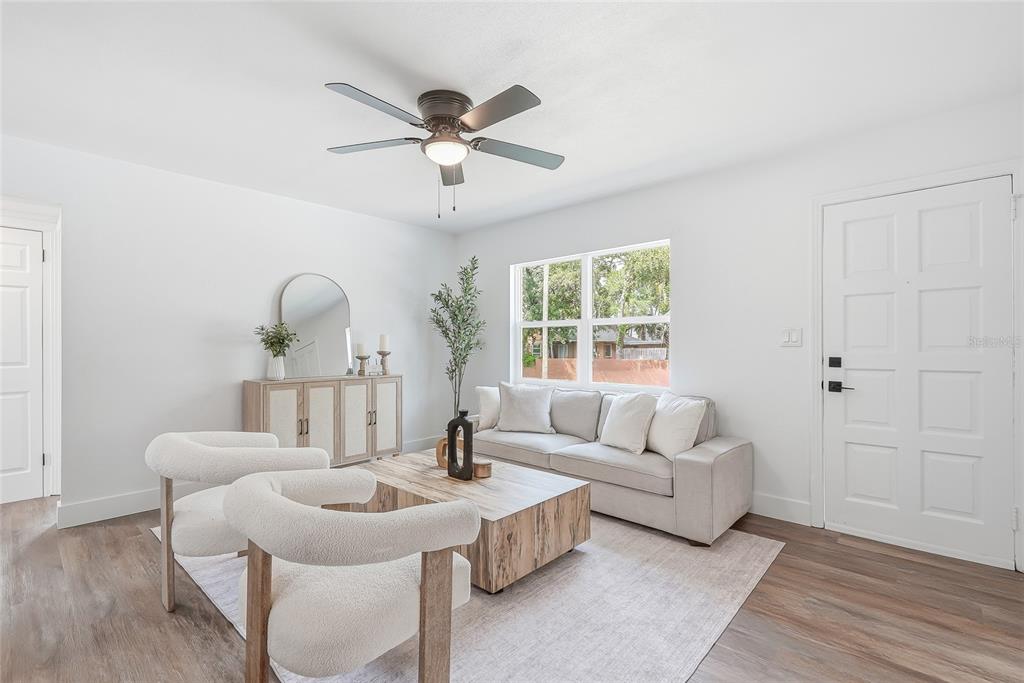 A living room features white walls, light wood flooring, a sofa, two chairs, and a ceiling fan — 2534 19TH STREET S, ST PETERSBURG, FL
