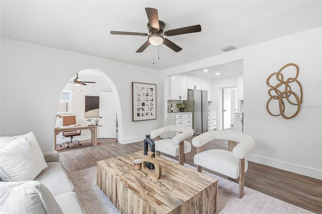 A living room with a wooden coffee table, two white chairs, and an arched entryway — 2534 19TH STREET S, ST PETERSBURG, FL