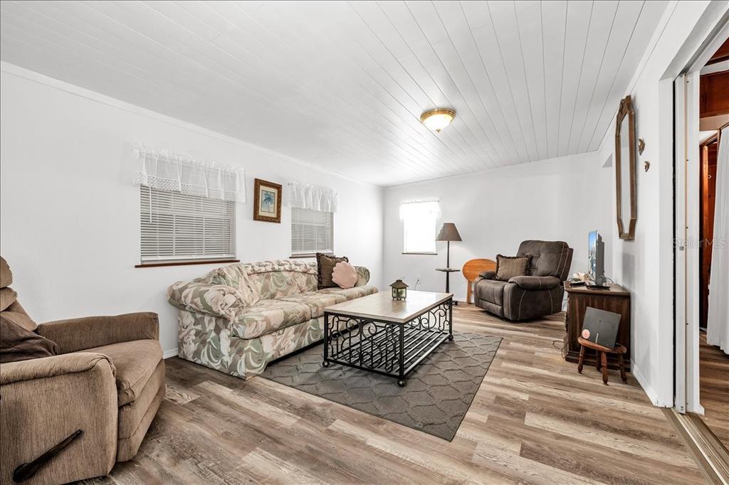 A living room features wood-look flooring, a floral sofa, two recliners, and a coffee table — 1235 MADONA COURT, PUNTA GORDA, FL
