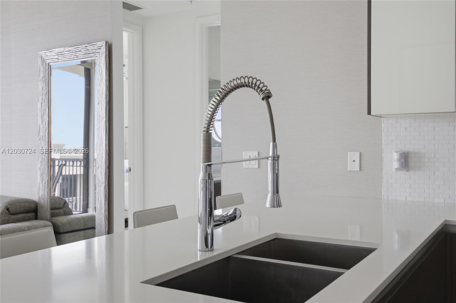 A kitchen island features a stainless steel pull-down faucet and a double-basin sink — 301 Altara Ave, Coral Gables FL 33146, CORAL GABLES, FL