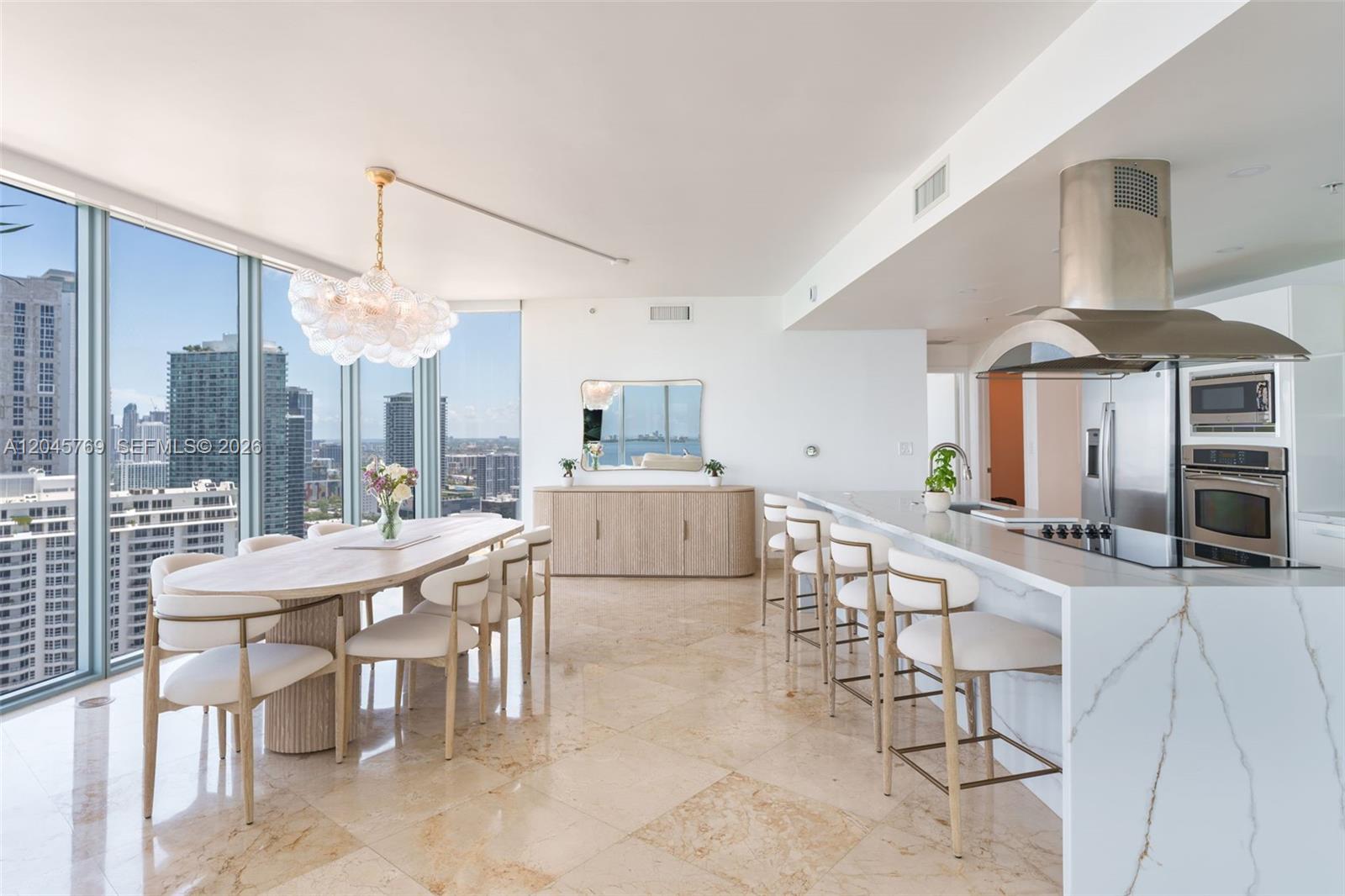 A modern high-rise dining area and kitchen with marble floors, floor-to-ceiling windows, and city views — 601 NE 36th St # 3112, Miami FL 33137, MIAMI, FL