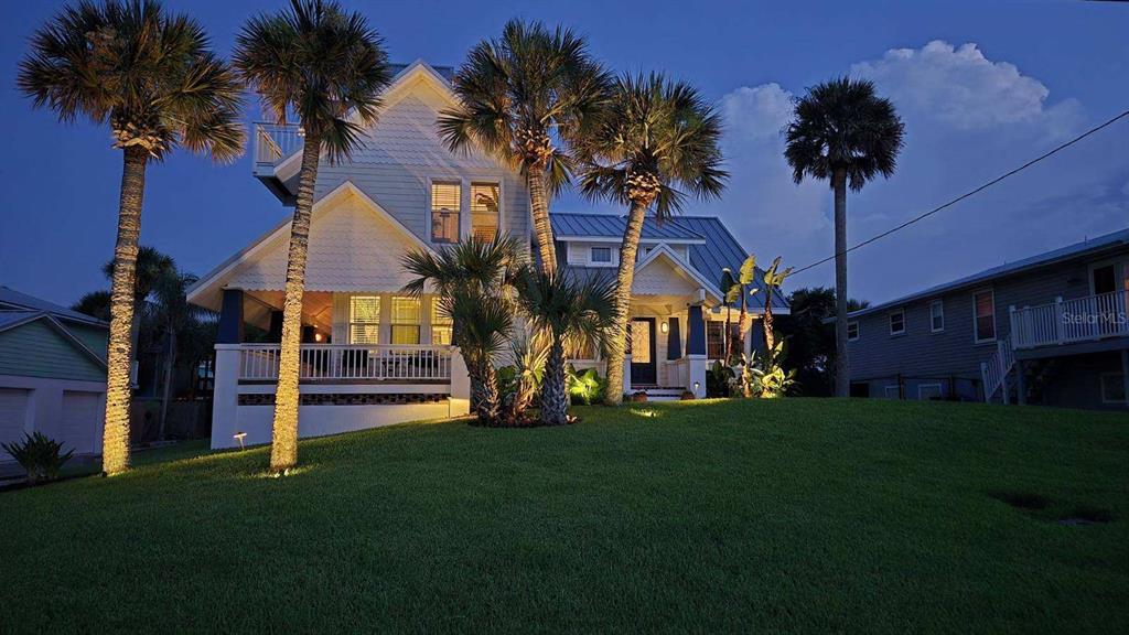 A multi-story house with a white exterior, porch, and palm trees at twilight — 315 DUE EAST STREET, NEW SMYRNA BEACH, FL