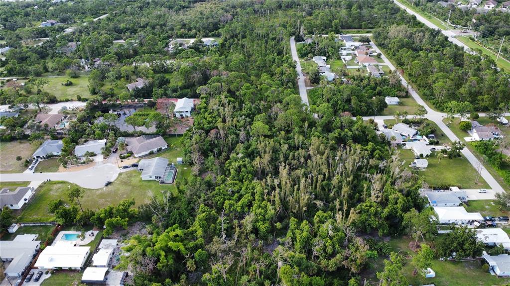 An aerial view shows a large, wooded lot surrounded by residential houses and paved streets — 2 BERTREND STREET, ENGLEWOOD, FL