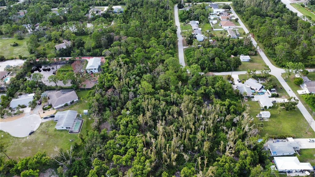An aerial view shows a wooded lot surrounded by residential houses and paved streets — 2 BERTREND STREET, ENGLEWOOD, FL