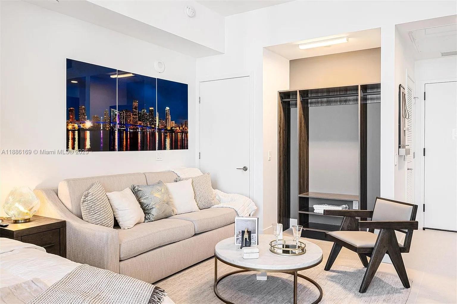 A living area features a beige sofa, a round marble coffee table, and open shelving — 159 NE 6th St # 5106, Miami FL 33132, MIAMI, FL