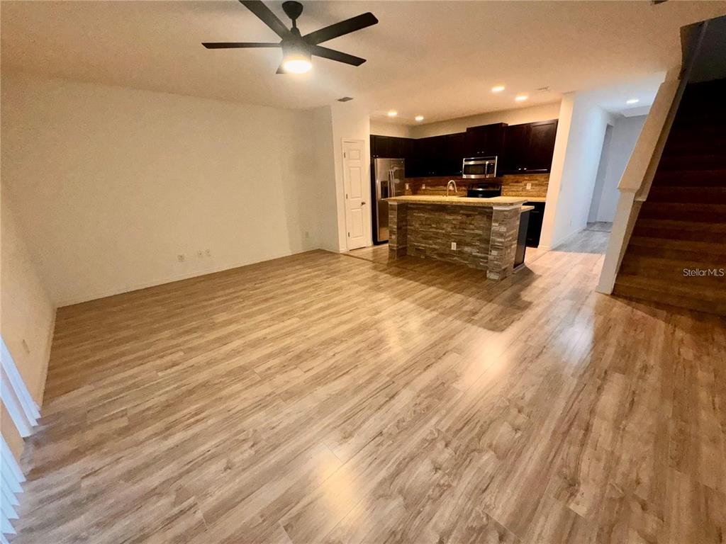 A brown six-panel front door with a welcome mat sits in a covered entryway — 2896 TANZANITE TERRACE, KISSIMMEE, FL