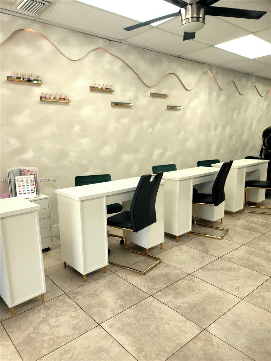 A nail salon features white manicure desks, black chairs, and wall-mounted shelves for polish — 4237 Hollywood Blvd, Hollywood FL 33021, HOLLYWOOD, FL