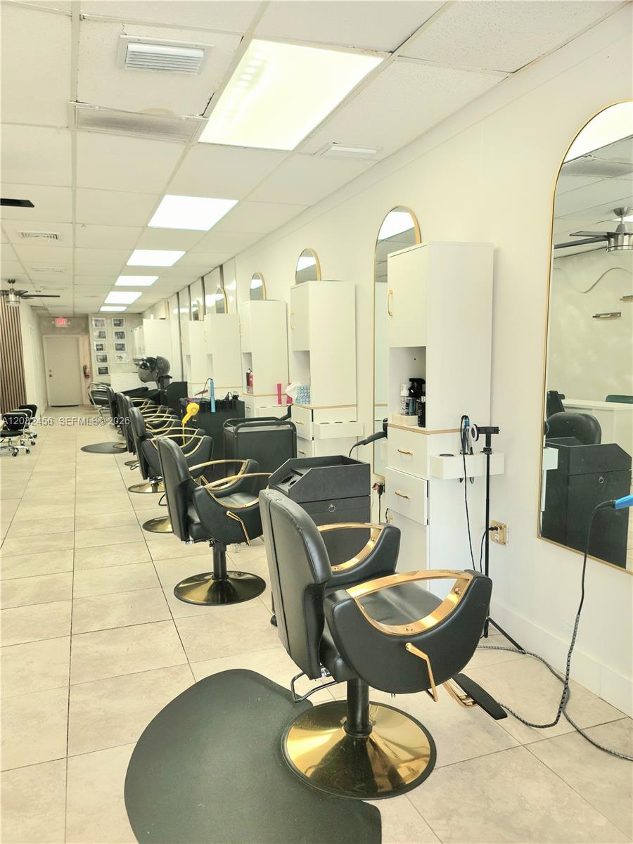 A hair salon features multiple styling stations with black chairs, gold accents, and large mirrors — 4237 Hollywood Blvd, Hollywood FL 33021, HOLLYWOOD, FL