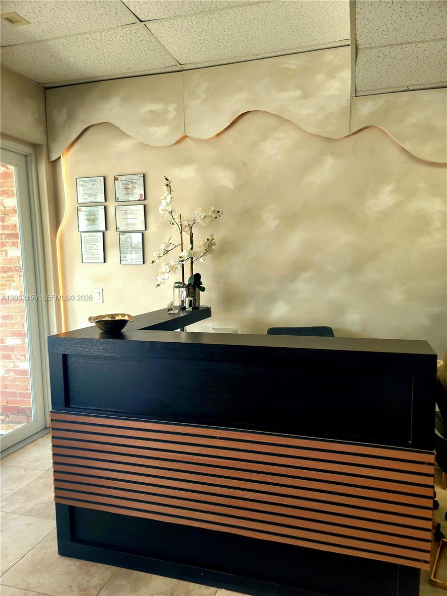 A black reception desk sits in front of a wall with framed certificates and decor — 4237 Hollywood Blvd, Hollywood FL 33021, HOLLYWOOD, FL