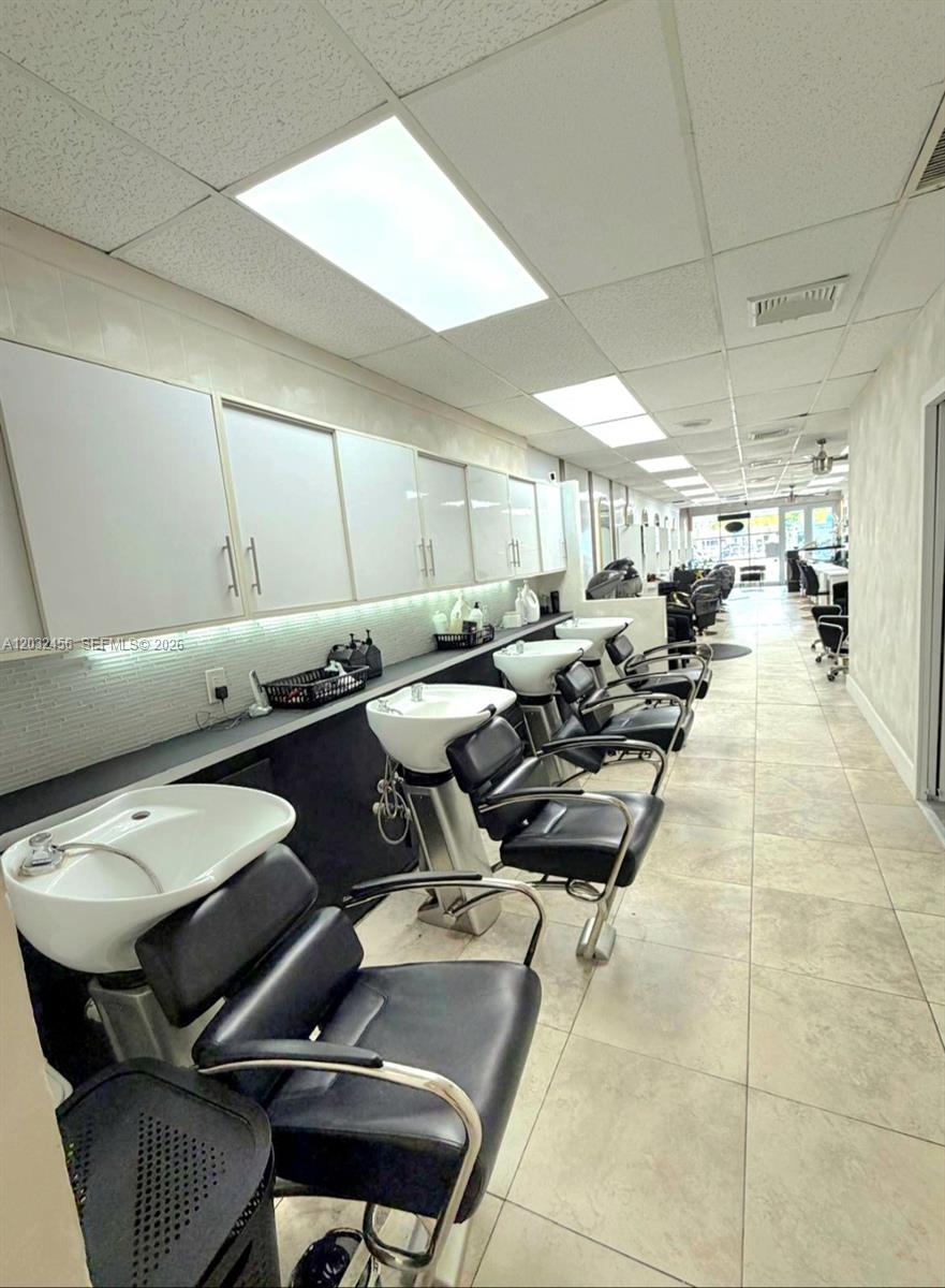A salon shampoo area features a row of black chairs with white sinks and cabinets — 4237 Hollywood Blvd, Hollywood FL 33021, HOLLYWOOD, FL
