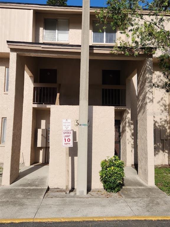 A two-story apartment building exterior features a central utility pole and a speed limit sign — 5507 POKEWEED COURT UNIT C, TAMPA, FL