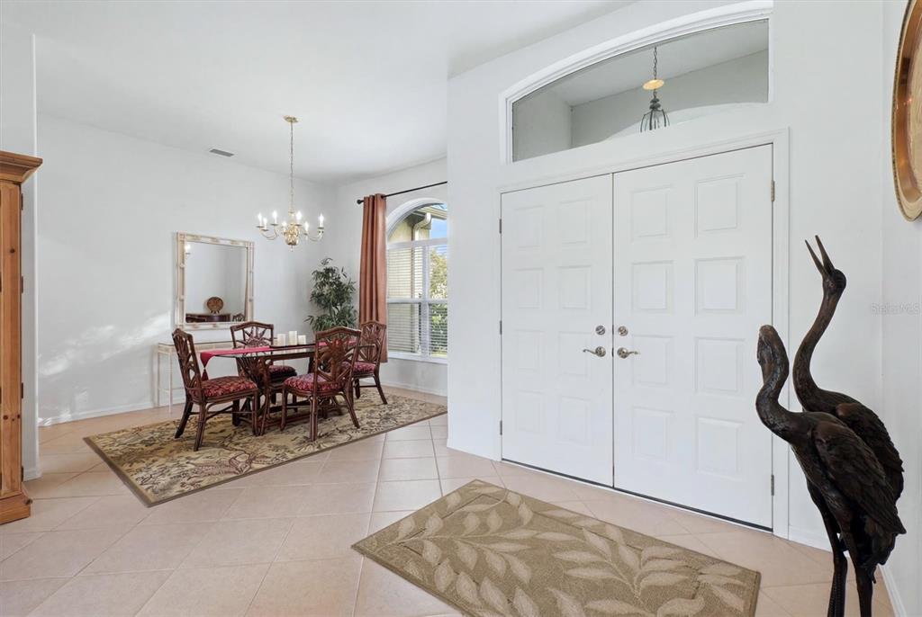 A covered entryway features double white doors, gray columns, and a tiled floor — 3175 VILLAGE LANE, PORT CHARLOTTE, FL