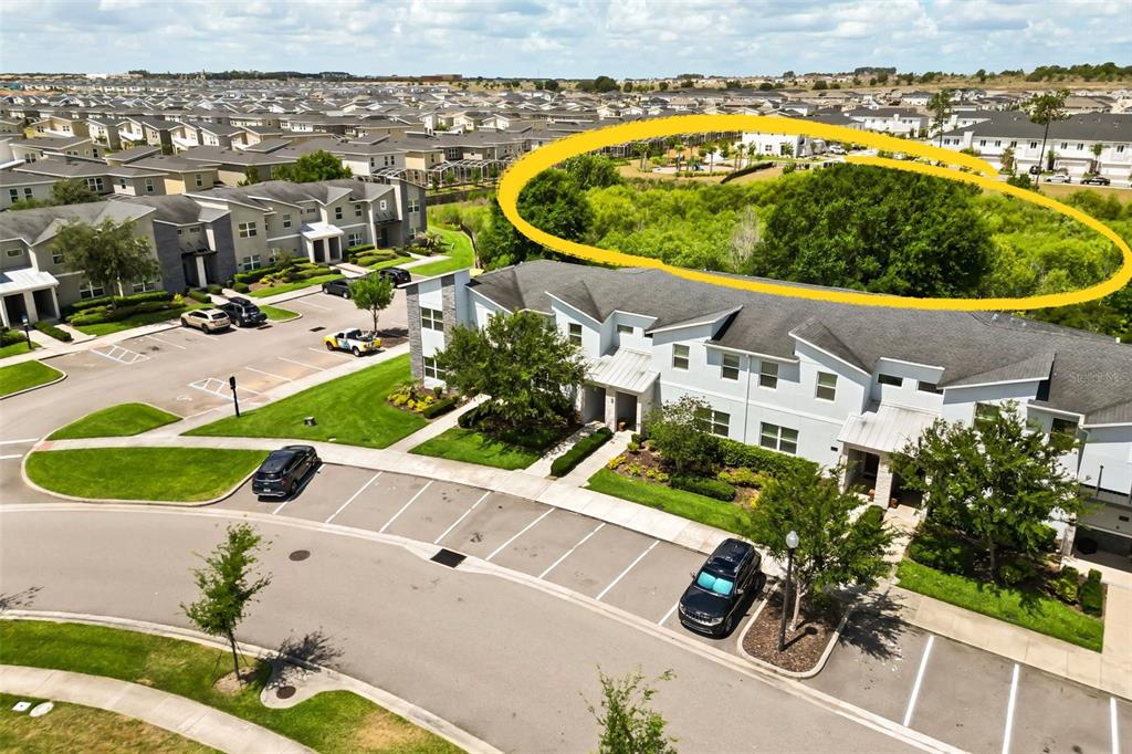 An aerial view shows a multi-family residential complex with a large, wooded green space behind — 374 OCEAN COURSE AVENUE, DAVENPORT, FL