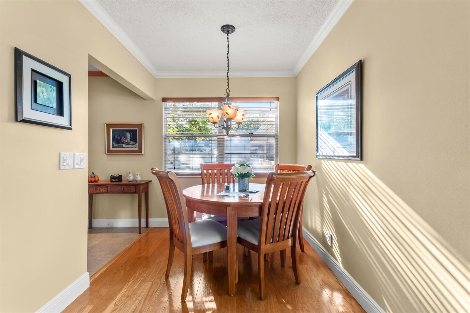 A dining area features a round wooden table, four chairs, and hardwood flooring — 144 Tilford G Place # 144, Deerfield Beach FL 33442, DEERFIELD BEACH, FL