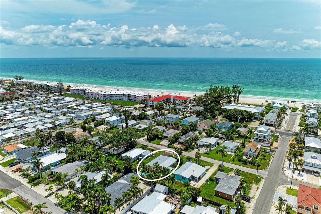 An aerial view shows a residential neighborhood near the beach with a circled house — 2711 AVENUE C, HOLMES BEACH, FL