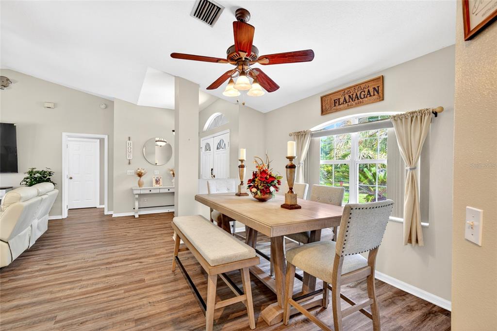 A dining room features a wooden table, a bench, upholstered chairs, and a ceiling fan — 15474 SW 28TH AVENUE RD, OCALA, FL