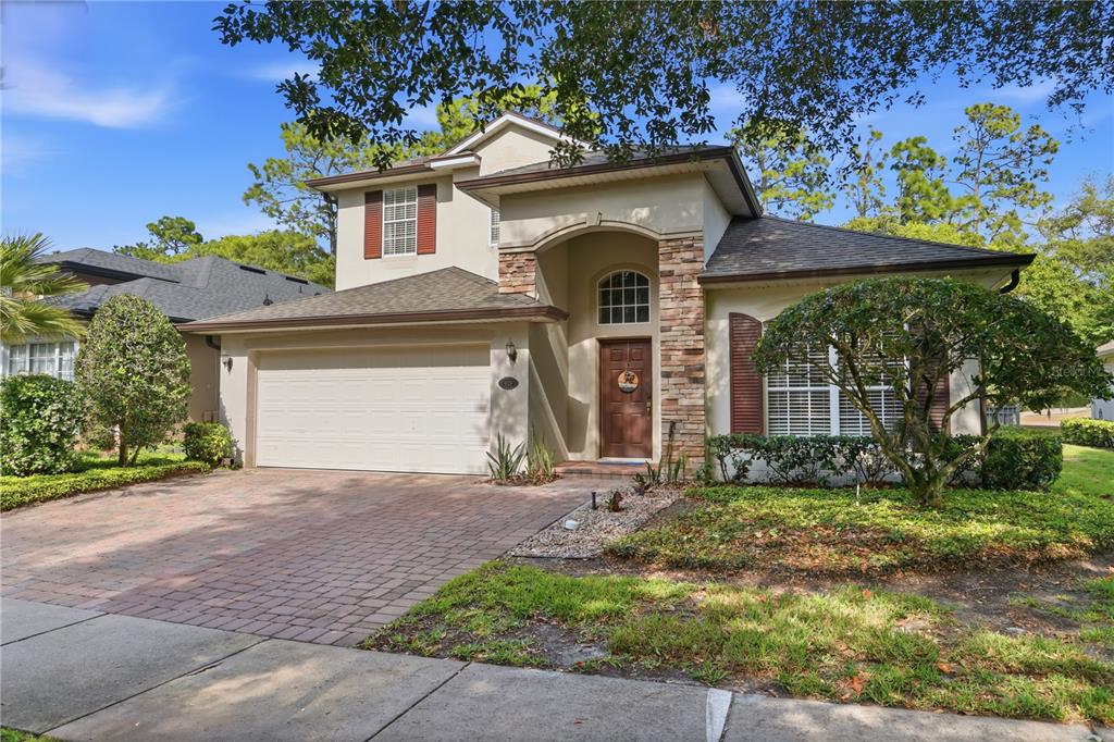 A two-story house with a stone-accented entryway, a two-car garage, and a brick paver driveway — 423 VICTORIA HILLS DRIVE, DELAND, FL