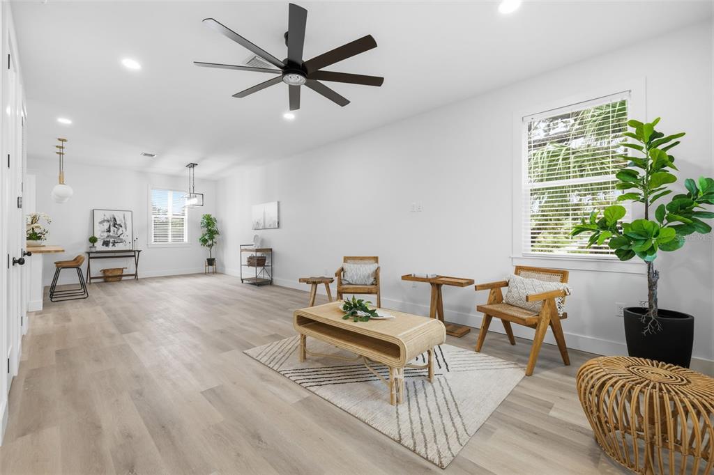 A bright living room features light wood flooring, a ceiling fan, and modern furniture — 2138 W NASSAU STREET UNIT 3, TAMPA, FL