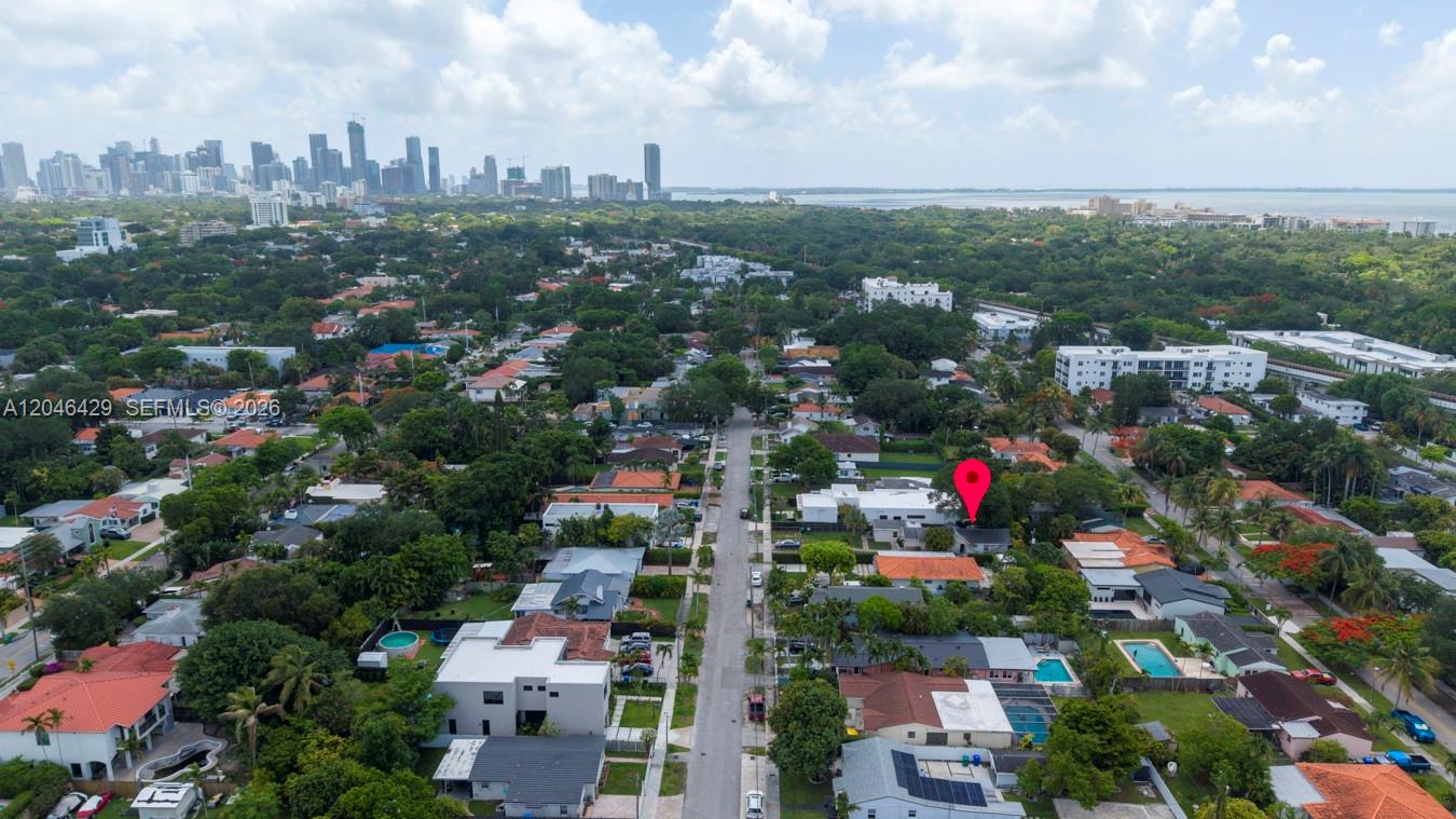 An aerial view shows a residential neighborhood with a red location pin over a house — MIAMI, FL