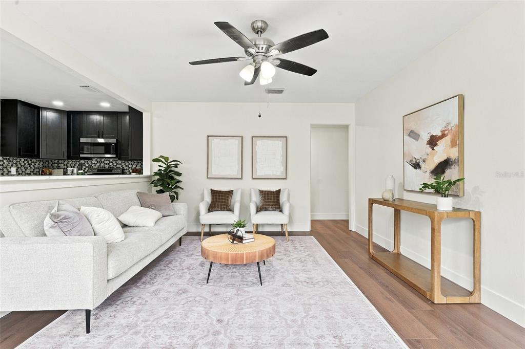 A living room features a grey sofa, two armchairs, a round coffee table, and wood flooring — 2506 DELANEY AVENUE, ORLANDO, FL