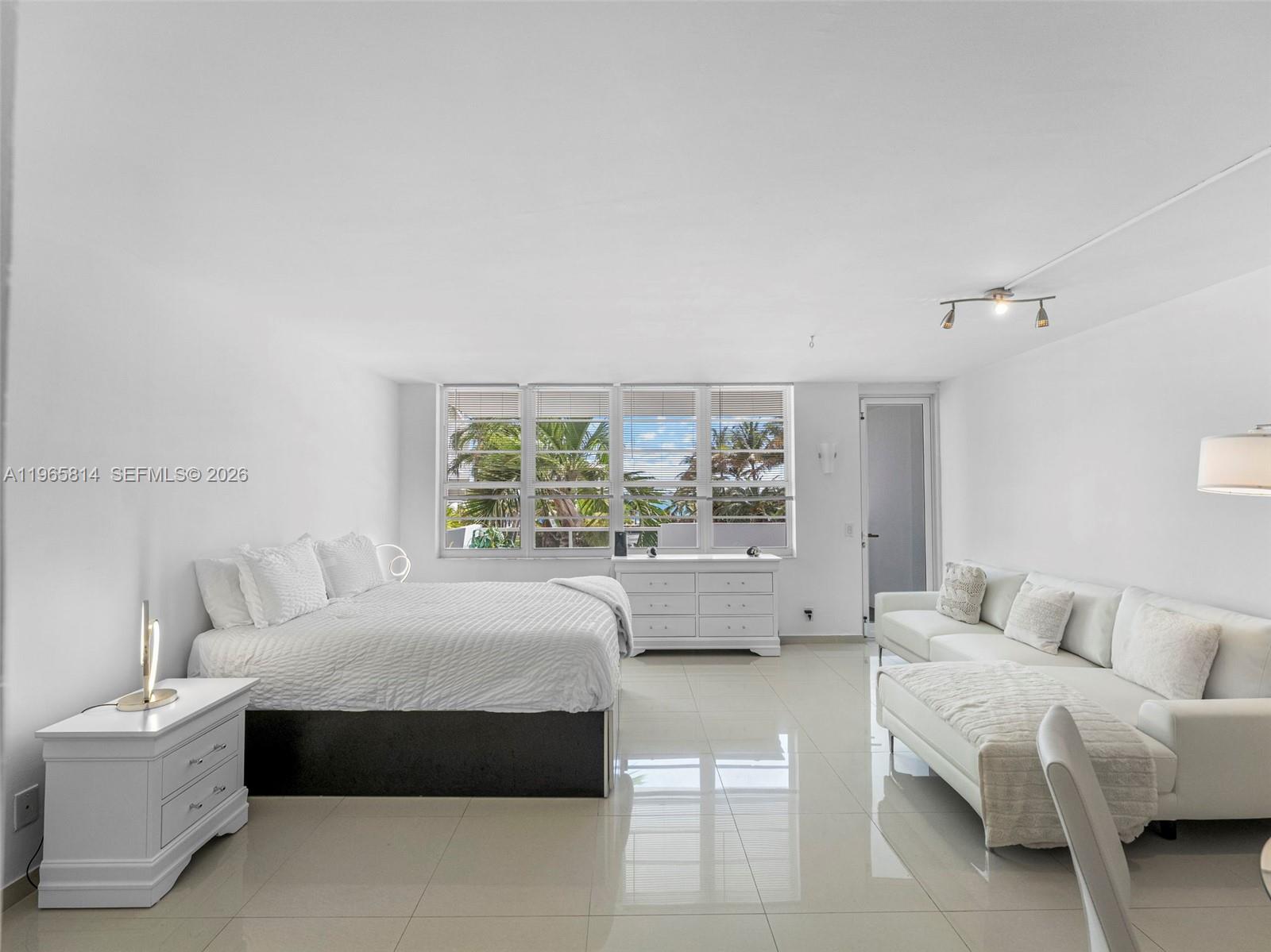 A bright bedroom features white tile floors, a bed, a sofa, and large windows — 100 Lincoln Rd # 417, Miami Beach FL 33139, MIAMI BEACH, FL