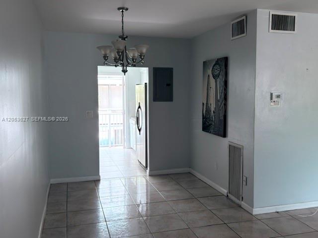 A dining area with light-colored tile flooring, a chandelier, and a view into a kitchen — 462 Golden Isles Dr # 203, Hallandale Beach FL 33009, HALLANDALE BEACH, FL