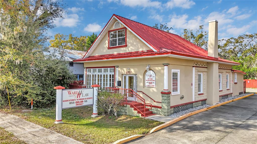 A single-story commercial building with a red metal roof and a prominent law firm sign — 1007 EMMETT STREET, KISSIMMEE, FL