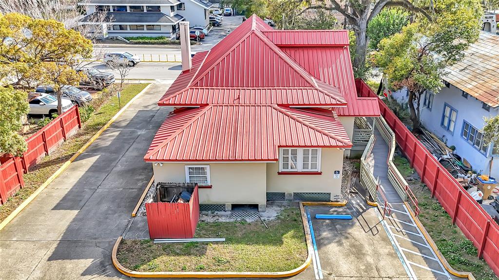 An aerial view shows a building with a red metal roof and a wheelchair ramp — 1007 EMMETT STREET, KISSIMMEE, FL