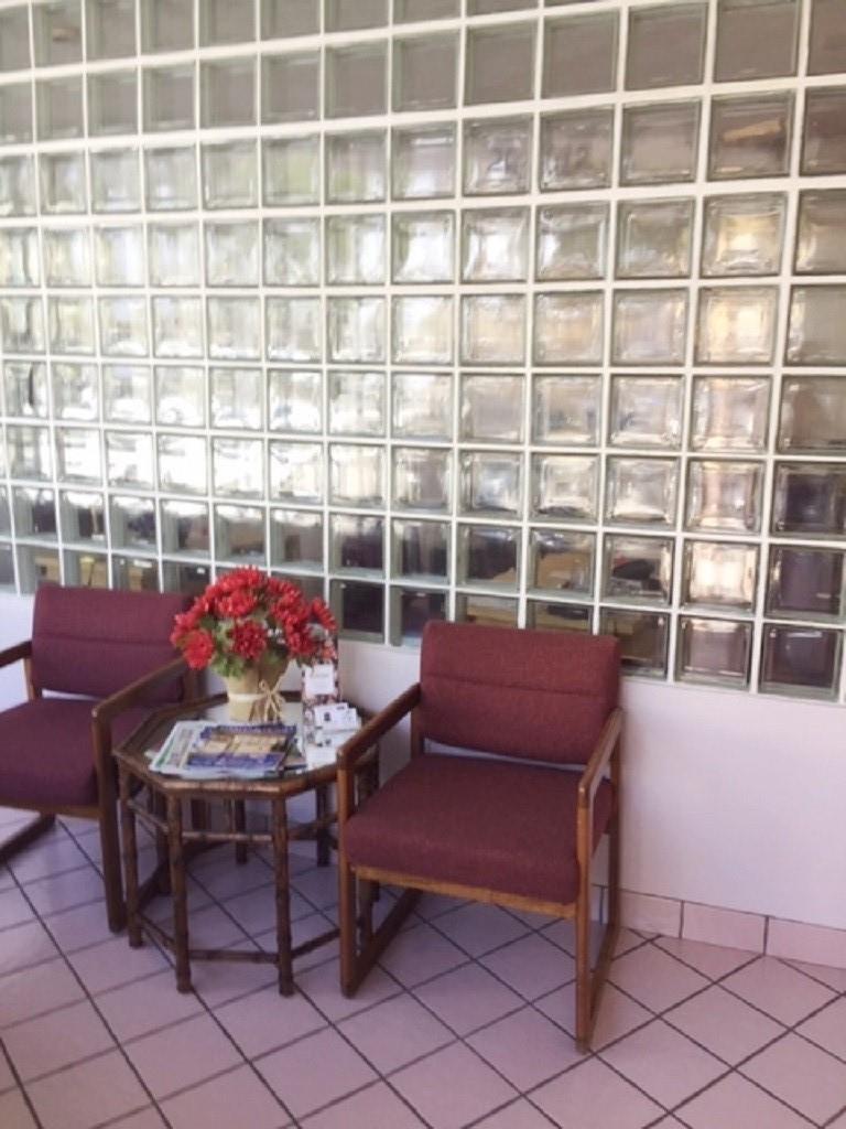 A waiting area features two maroon chairs, a small table, and a glass block wall — 2012 Hollywood Bl # D, Hollywood FL 33020, HOLLYWOOD, FL