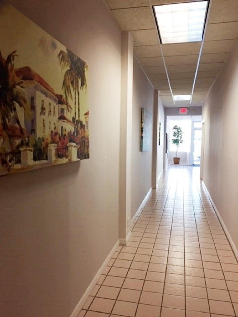 A long hallway features light-colored tile flooring, beige walls, and a drop ceiling with lights — 2012 Hollywood Bl # D, Hollywood FL 33020, HOLLYWOOD, FL