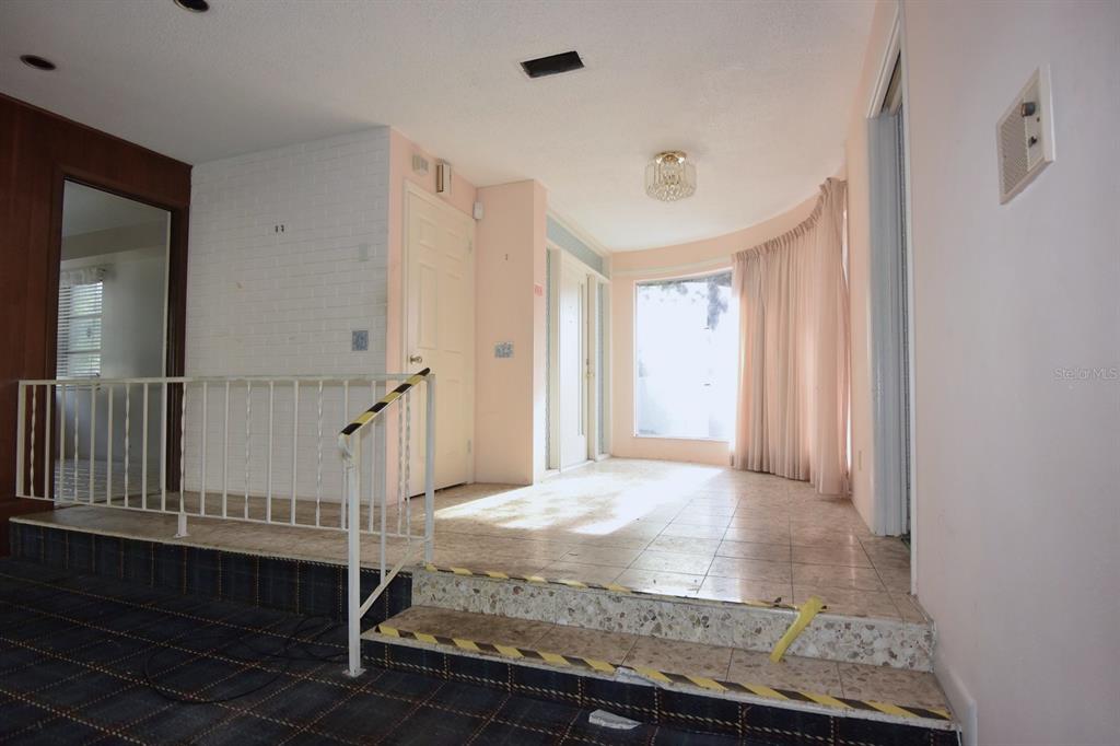 An interior view shows a tiled entryway with a step up to a carpeted area — 7124 JASMIN DRIVE, NEW PORT RICHEY, FL