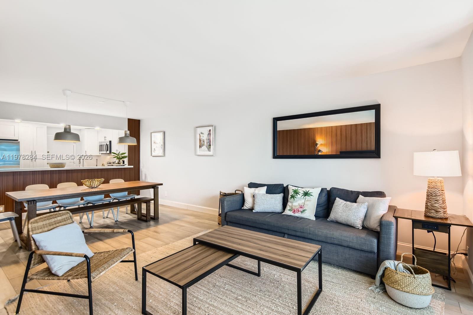 A living room and dining area feature a dark sofa, wood-topped tables, and pendant lighting — 3800 S Ocean Dr, Hollywood FL 33019, HOLLYWOOD, FL