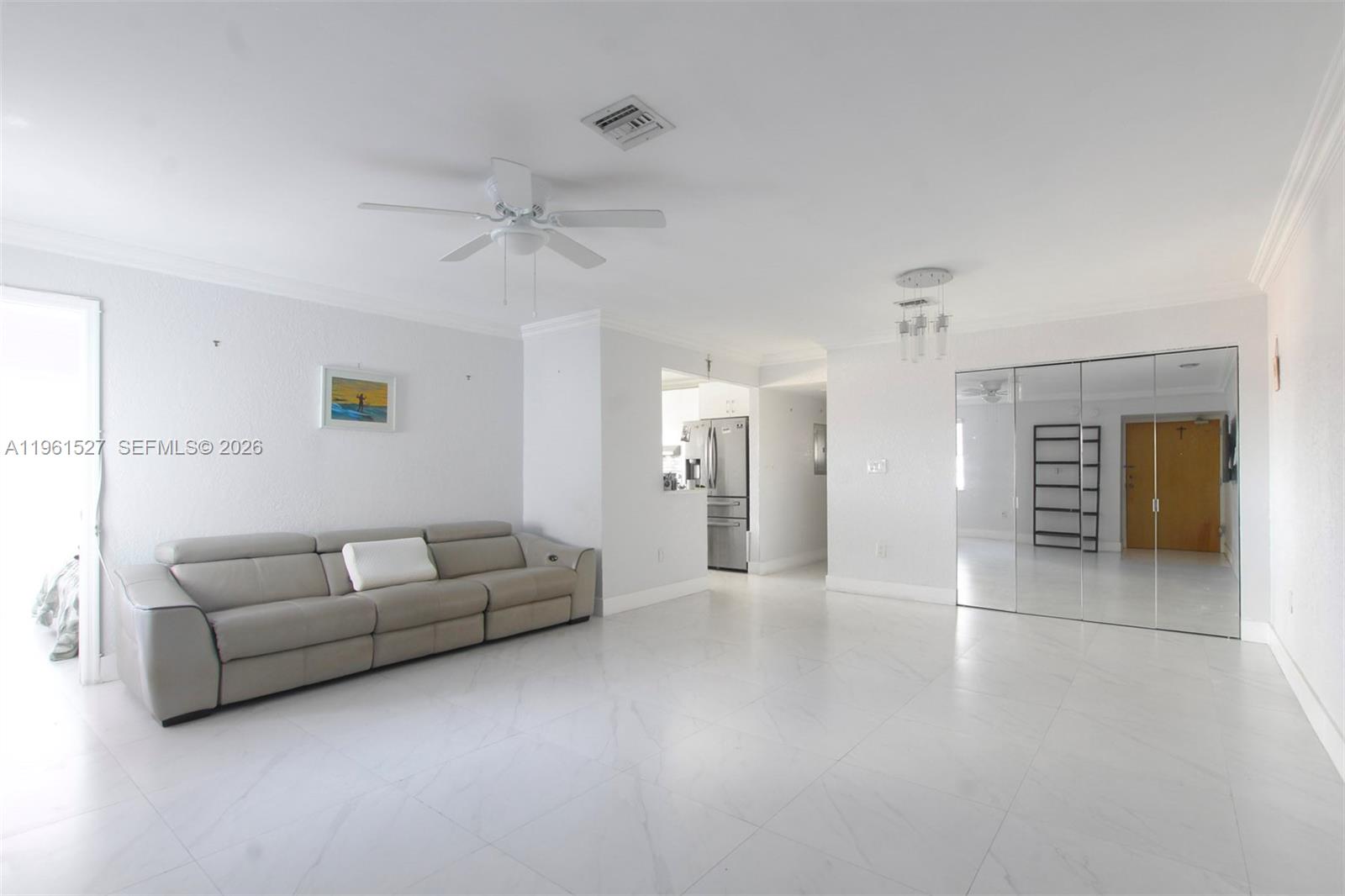 A living room features white tile flooring, a gray sofa, and mirrored closet doors — 49 Majorca Ave # 303, Coral Gables FL 33134, CORAL GABLES, FL