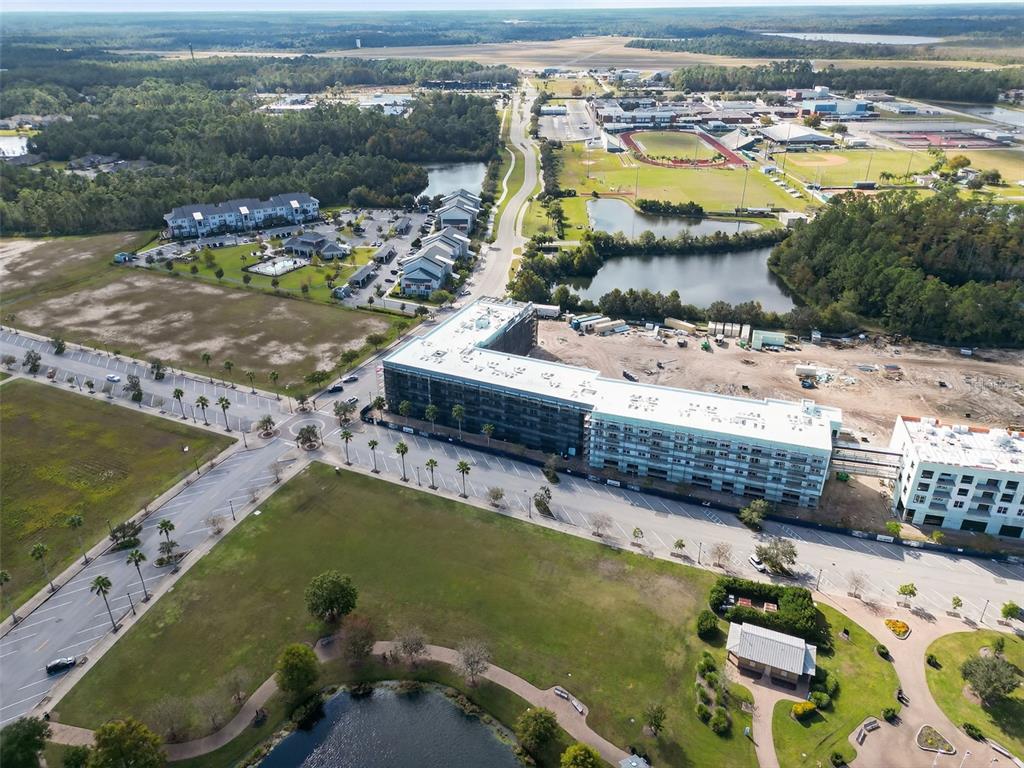 An aerial view shows a large multi-story apartment building under construction near a park — 469 BULLDOG DRIVE UNIT 4, PALM COAST, FL