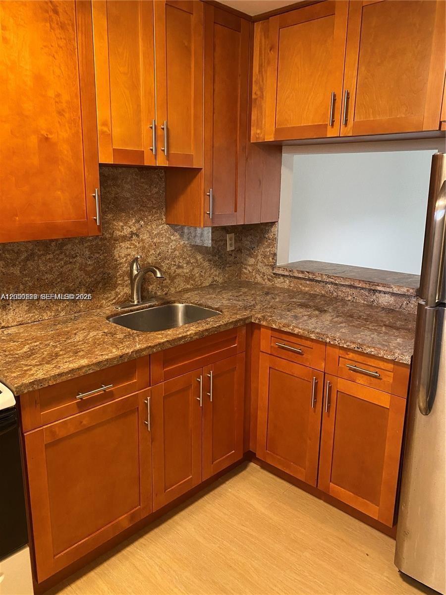A kitchen features wood cabinets, a brown laminate countertop, and a stainless steel sink — 11307 SW 200th St # B, Miami FL 33157, MIAMI, FL