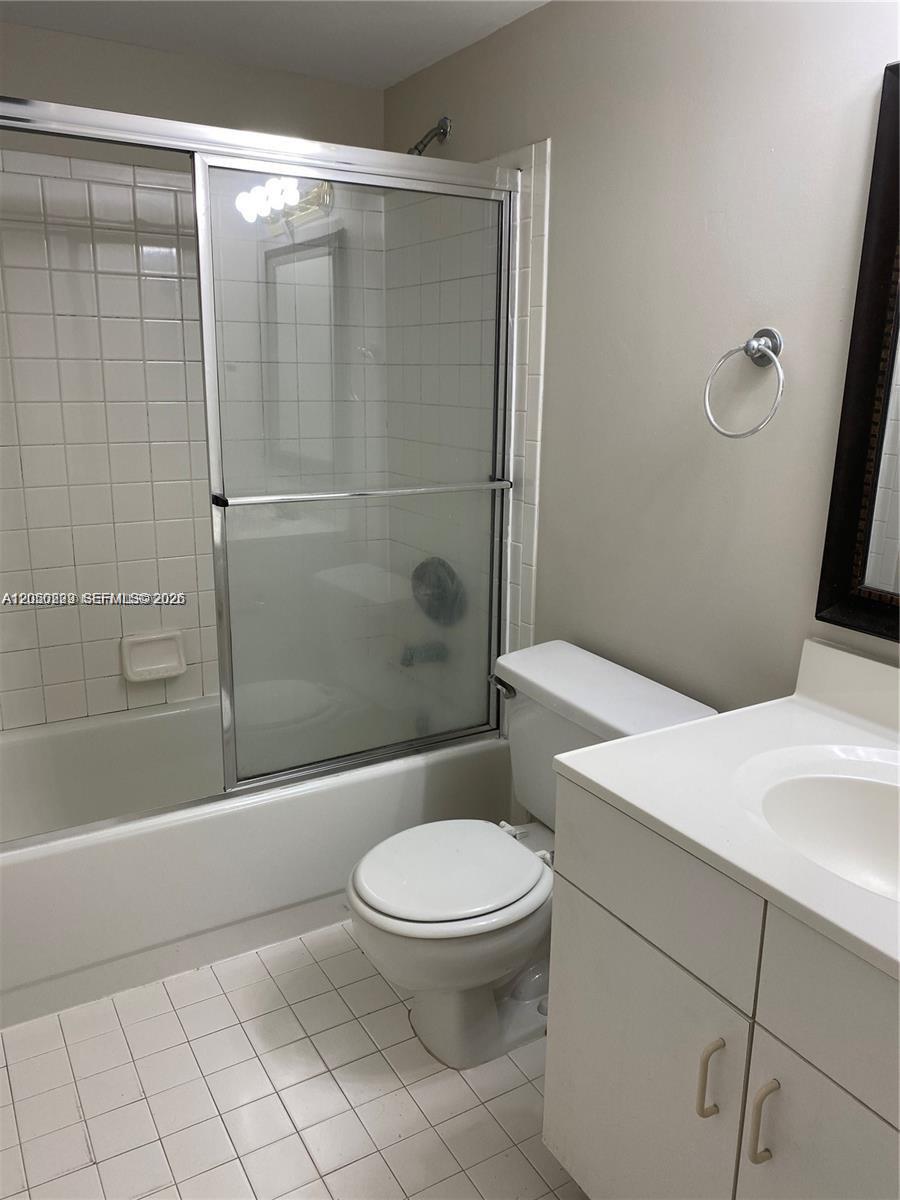 A bathroom features a white vanity, a toilet, and a shower-tub combination with sliding doors — 11307 SW 200th St # B, Miami FL 33157, MIAMI, FL