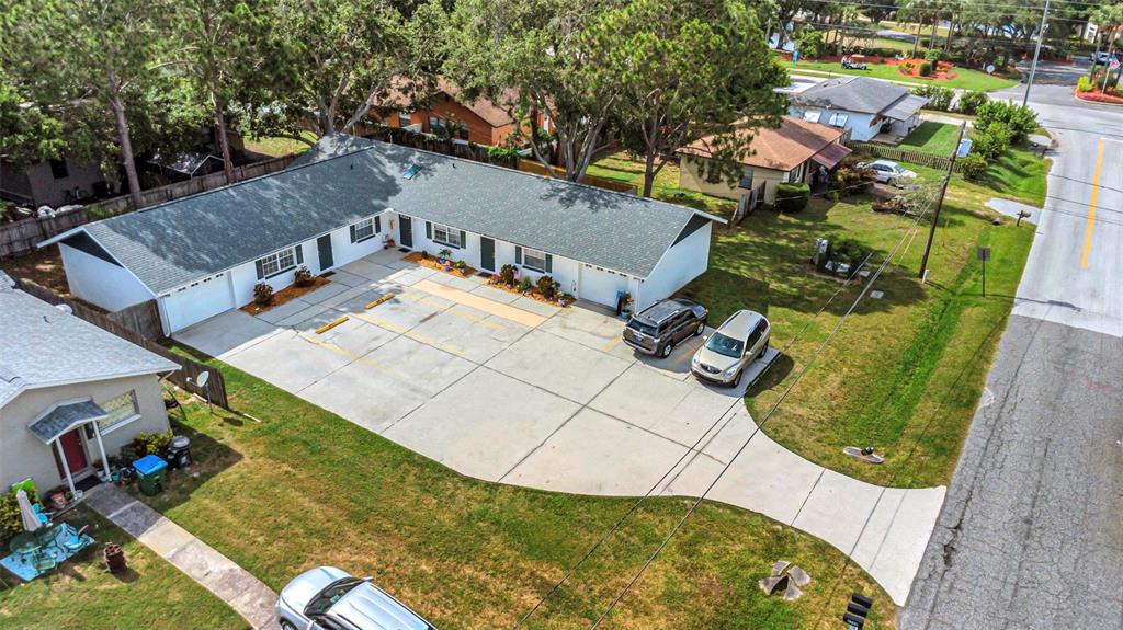 An aerial view shows a single-story multi-unit building with a large concrete parking area — 2780 CYPRESS DRIVE UNIT B, CLEARWATER, FL
