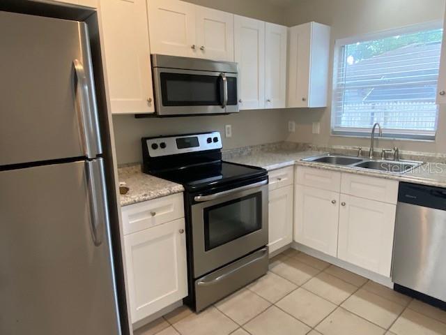 A kitchen features white cabinets, stainless steel appliances, and a window above the sink — 2780 CYPRESS DRIVE UNIT B, CLEARWATER, FL