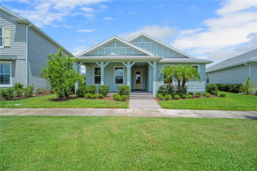 A light blue single-story house with a front porch and a paved walkway — 17057 PINE LILY LANE, PUNTA GORDA, FL