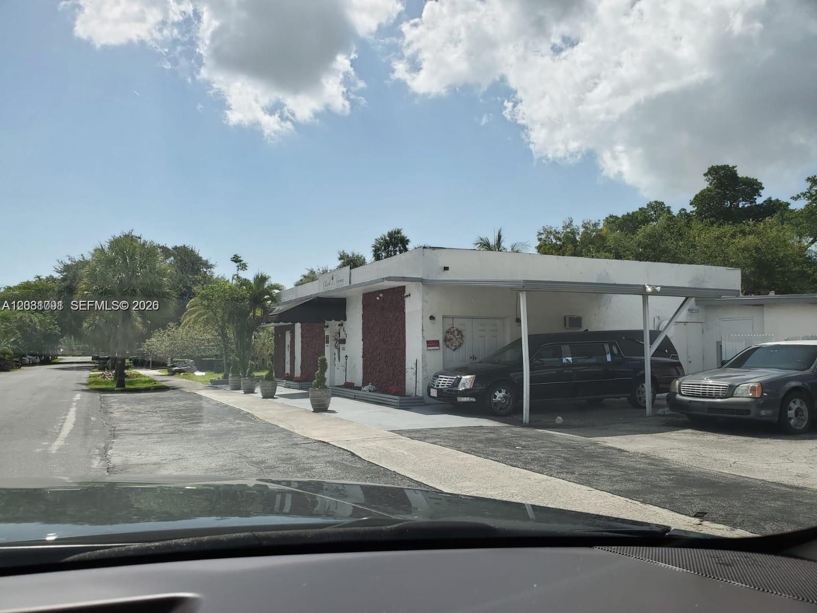 A white commercial building with a carport and two parked vehicles under a blue sky — 608 SW 12th Ave, Dania Beach FL 33004, DANIA BEACH, FL