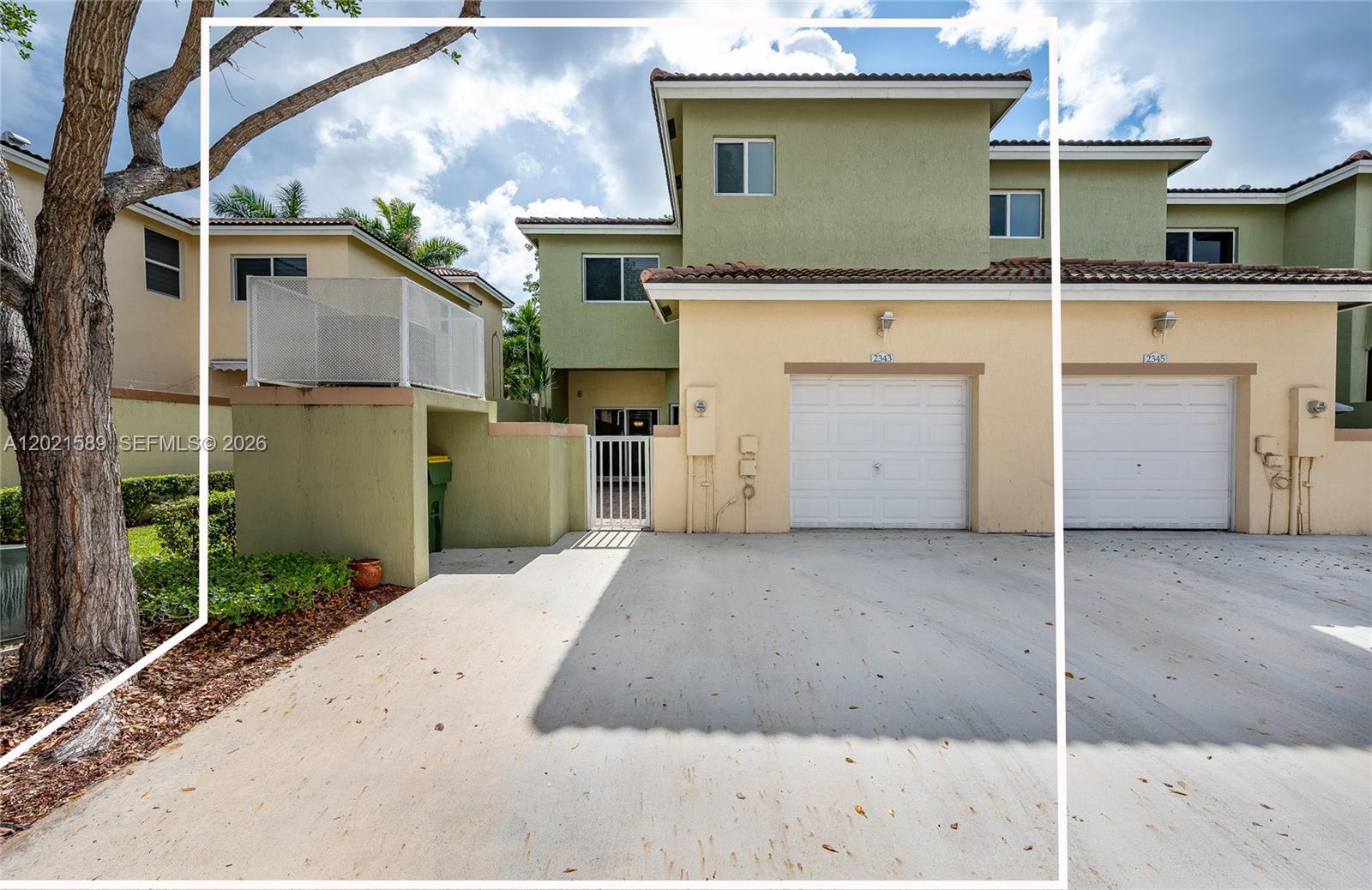 An exterior view of a two-story townhouse with a garage and a concrete driveway — 2343 SE 16th Pl, Homestead FL 33035, HOMESTEAD, FL